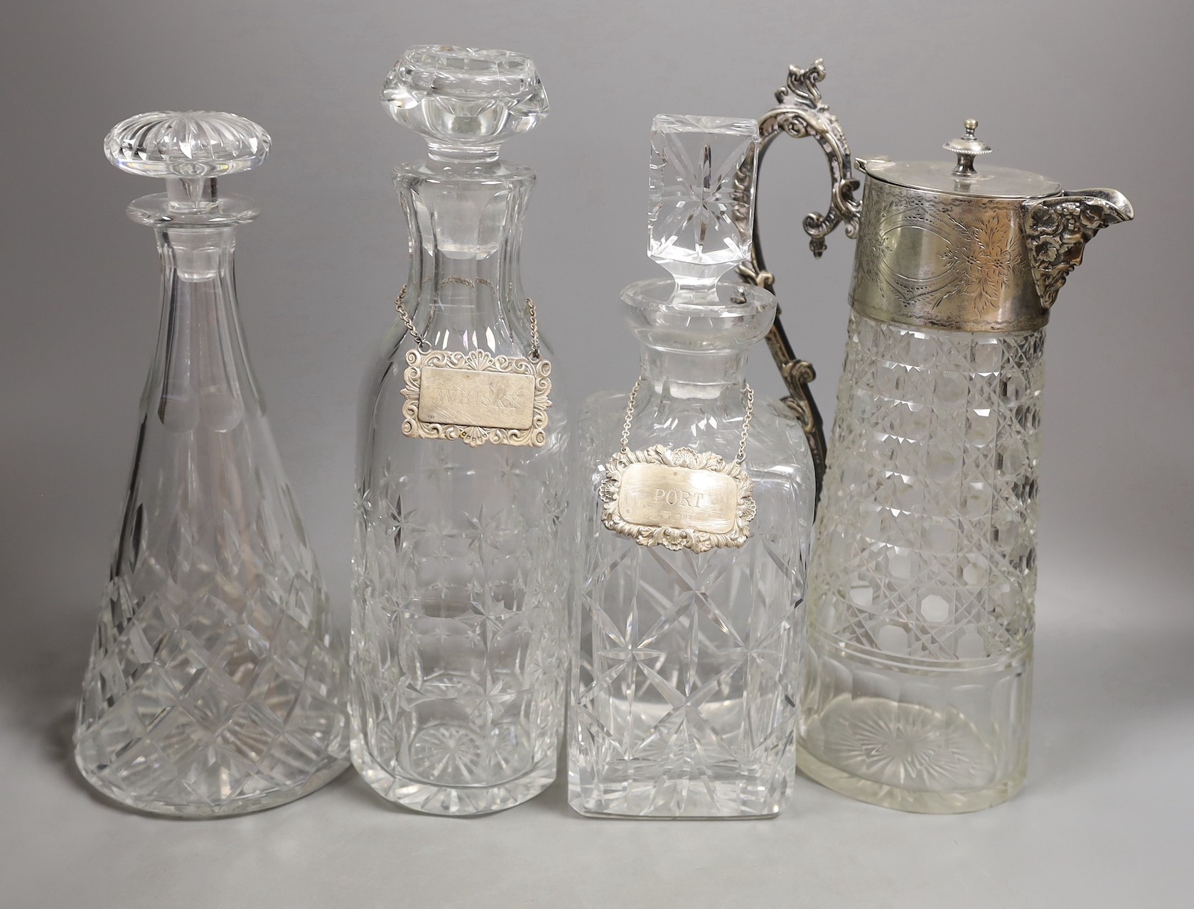 Three various cut glass decanters and a silver plated claret jug-, Claret jug 26 cms high.